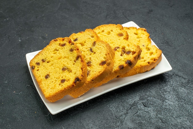 Vista frontal delicioso bolo fatiado dentro do prato na superfície escura doce bolo biscoito chá torta chá