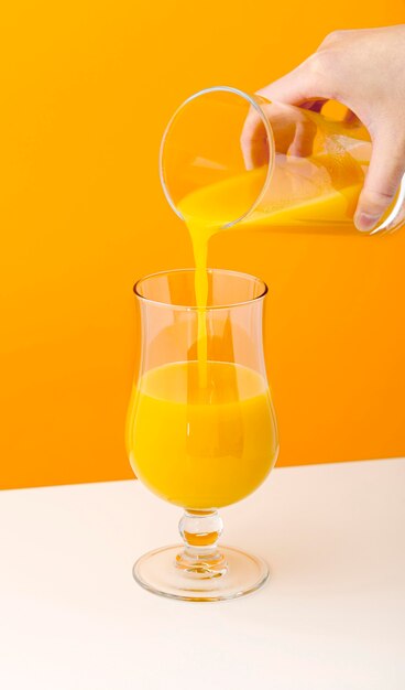 Vista frontal delicioso smoothie de laranja sendo derramado