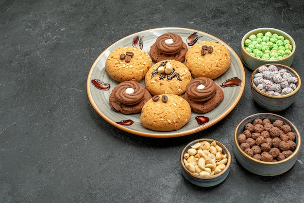 Vista frontal deliciosos biscoitos doces, doces saborosos para o chá no espaço cinza