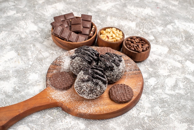 Foto grátis vista frontal deliciosos bolos de chocolate com biscoitos e nozes no espaço em branco