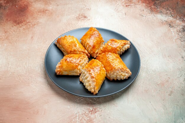 Vista frontal deliciosos pastéis doces dentro do prato na mesa branca torta bolo pastelaria doce