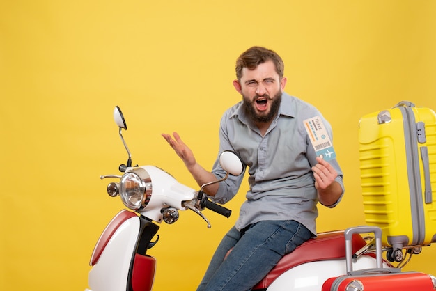 Foto grátis vista frontal do conceito de viagens com jovem preocupado sentado na moto com as malas segurando o bilhete amarelo