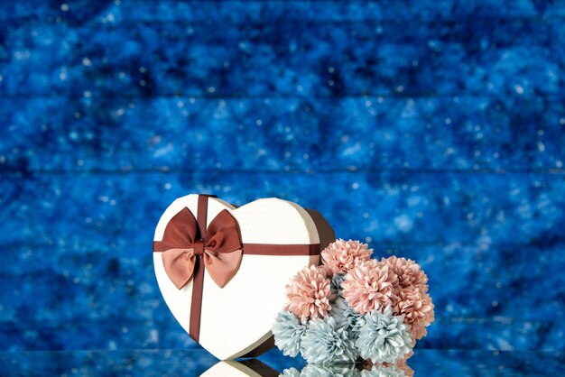 Vista frontal do dia dos namorados presente com flores sobre fundo azul amor família casamento sentimento beleza nuvem cores paixão amante
