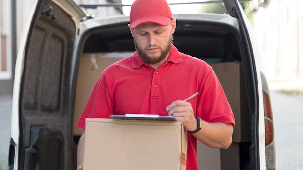 Foto grátis vista frontal do entregador com um pacote
