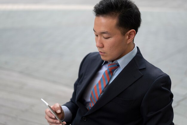 Vista frontal do homem de negócios com smartphone