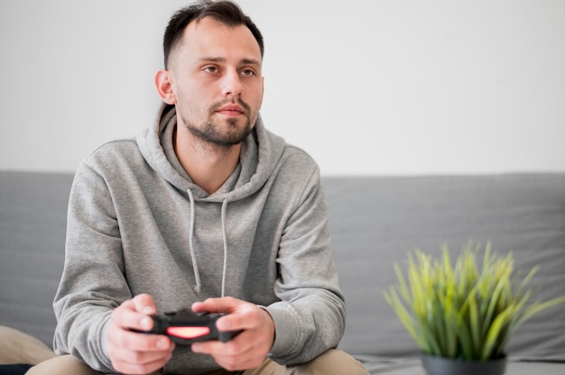 Foto grátis vista frontal do homem jogando videogame