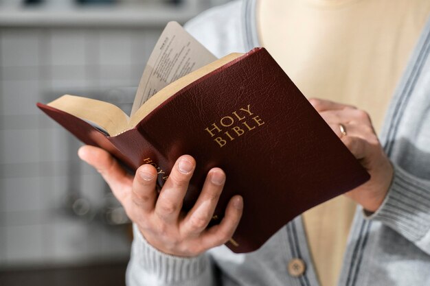Vista frontal do homem segurando a Bíblia