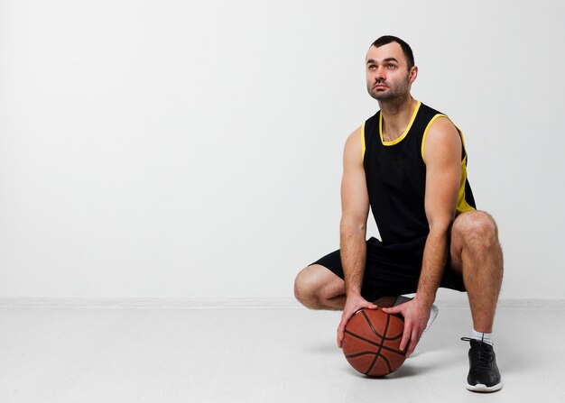 Vista frontal do homem segurando basquete com espaço de cópia