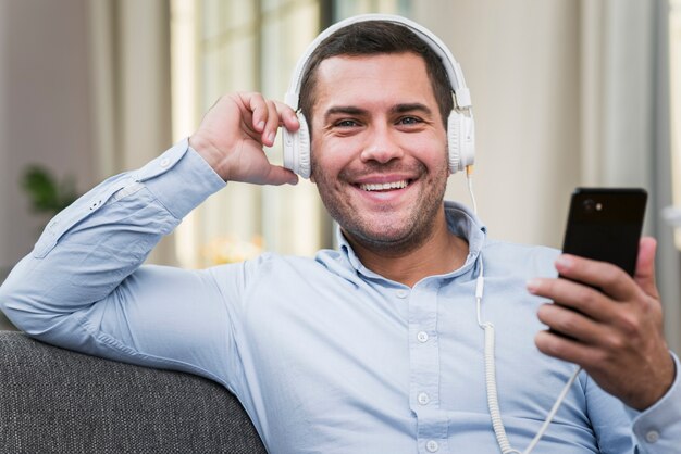 Vista frontal do homem sorridente, ouvindo música