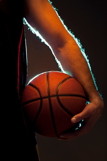 Vista frontal do jogador de basquete, segurando uma bola