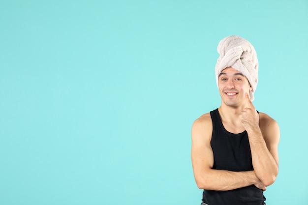Foto grátis vista frontal do jovem após o banho na parede azul