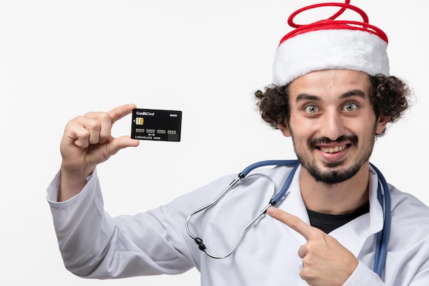 Foto grátis vista frontal do médico segurando o cartão do banco na parede branca