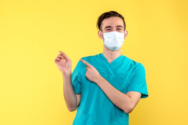 Vista frontal do médico sorrindo na parede amarela