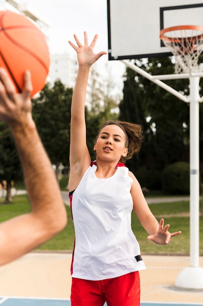 Vista frontal do menino e menina jogando basquete