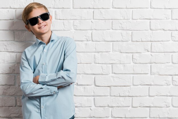 Vista frontal do menino moderno com óculos de sol