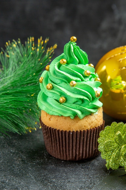 Foto grátis vista frontal do mini cupcake da árvore de natal e detalhes do natal no fundo escuro isolado