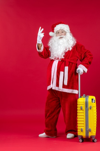 Vista frontal do papai noel com bolsa amarela se preparando para a viagem na parede vermelha