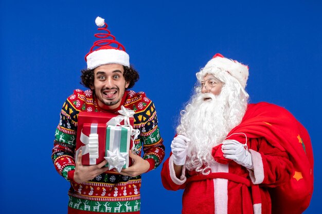 Vista frontal do papai noel com jovem macho e presentes nas cores azuis emoção do feriado de natal