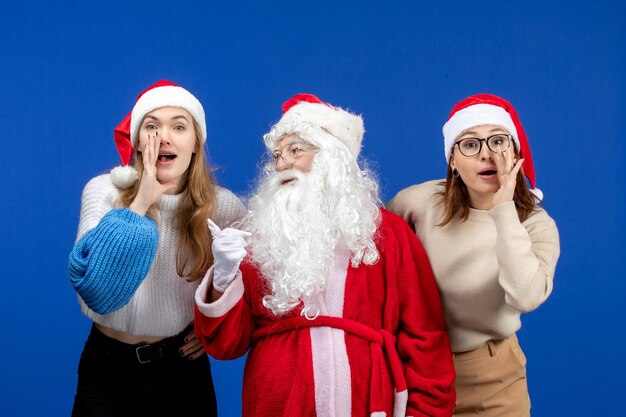 Vista frontal do papai noel com mulheres sussurrando na cor azul emoção neve ano novo natal