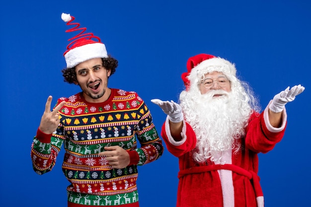 Vista frontal do Papai Noel com o jovem na parede azul