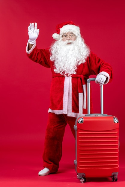 Foto grátis vista frontal do papai noel com sua bolsa vermelha na parede vermelha