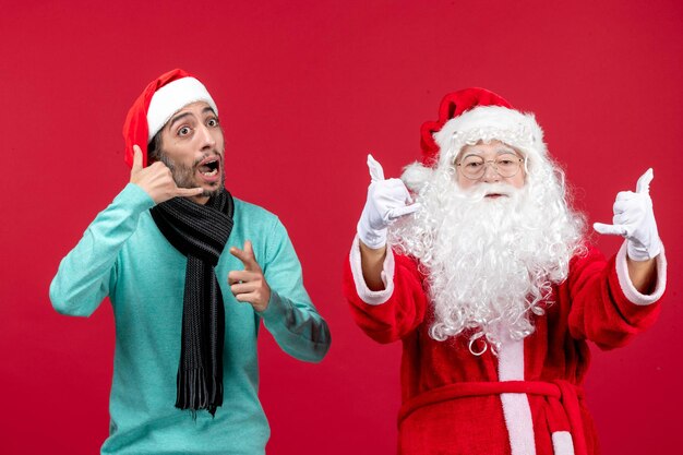 Vista frontal do papai noel com um homem em pé na emoção de Natal vermelho presente nas férias