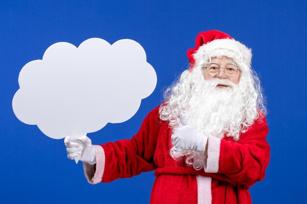 Vista frontal do papai noel segurando uma grande nuvem em forma de cartaz na cor azul da neve.