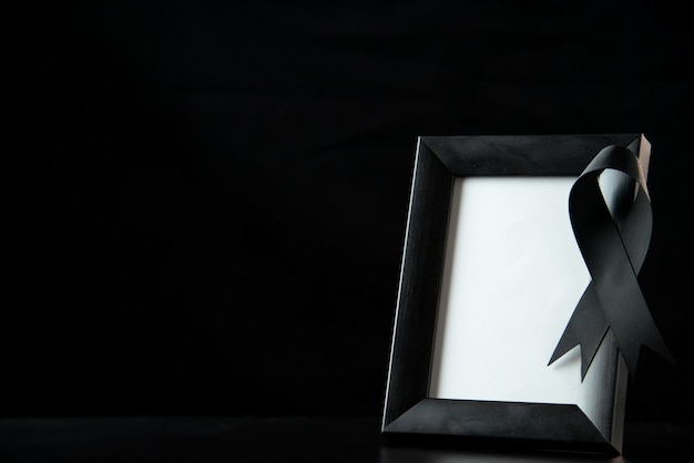 Foto grátis vista frontal do porta-retrato com laço preto no escuro