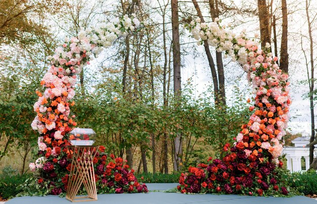 Vista frontal do rico arco decorado com adoráveis flores rosas frescas