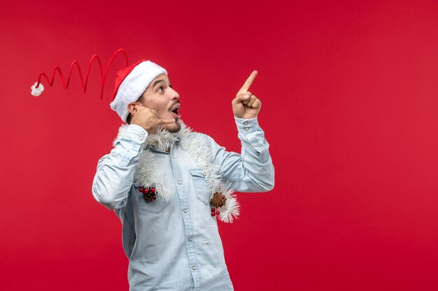 Vista frontal do sexo masculino jovem imitando telefonema, feriado natal