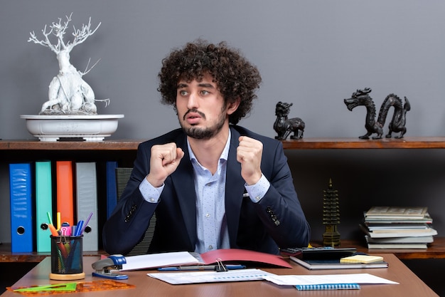 Vista frontal do trabalhador de escritório sentado à mesa no escritório