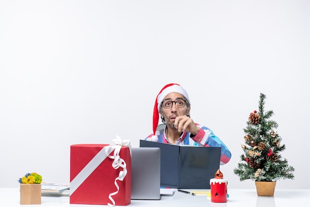 Vista frontal do trabalhador masculino sentado em seu local de trabalho lendo caderno escritório natal negócio trabalho emoção