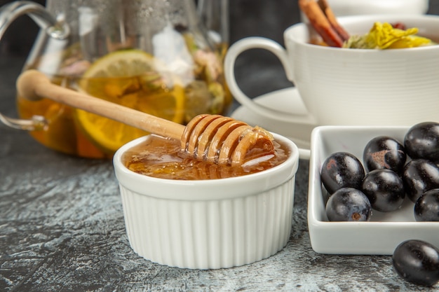 Vista frontal, doce mel com chá e azeitonas na superfície escura, café da manhã