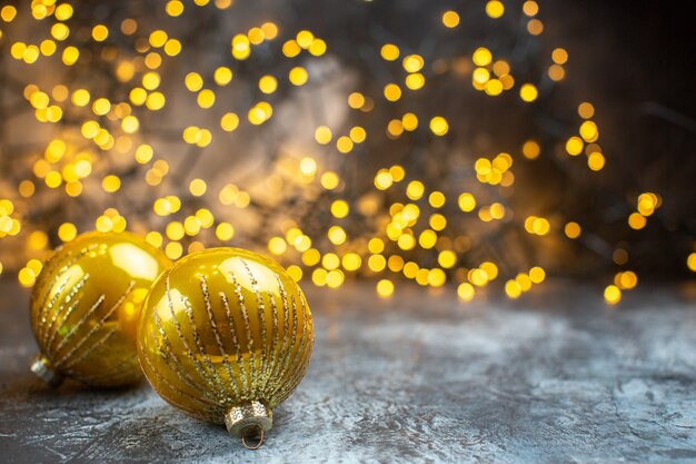 Vista frontal dos brinquedos da árvore de natal com luzes amarelas na foto claro-escuro na cor do ano novo de natal