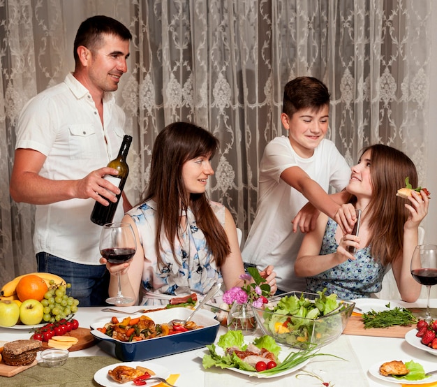 Foto grátis vista frontal dos pais com os filhos na mesa de jantar