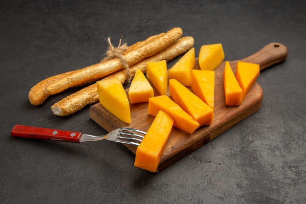 Vista frontal em fatias de queijo fresco com pãezinhos e salgadinhos de cor escura