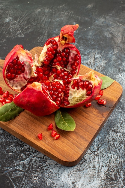 Vista frontal em fatias de romãs frutas vermelhas frescas na mesa de luz frutas vermelhas frescas