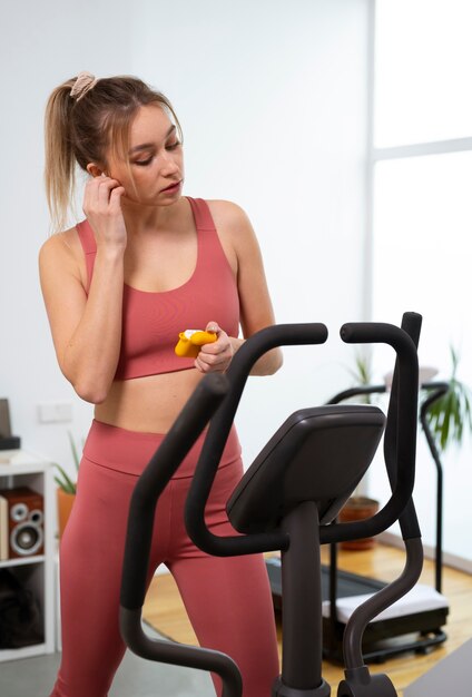 Vista frontal em forma de mulher se exercitando em casa