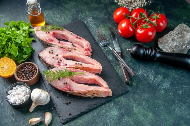 vista frontal fatias de peixe fresco com verdes e tomates na superfície azul escuro frutos do mar salada refeição oceano jantar cor carne crua água fotos