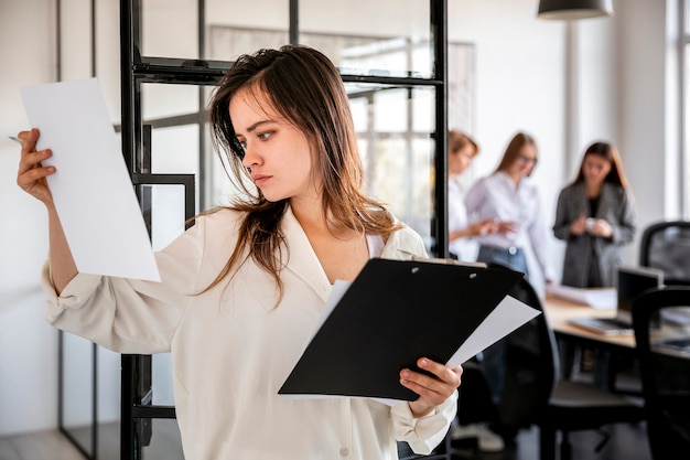 Vista frontal feminina no escritório, verificação de planos