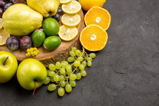 Vista frontal frutas frescas uvas fatias de limão ameixas e marmelos em fundo escuro árvore de vitaminas de frutas frescas maduras