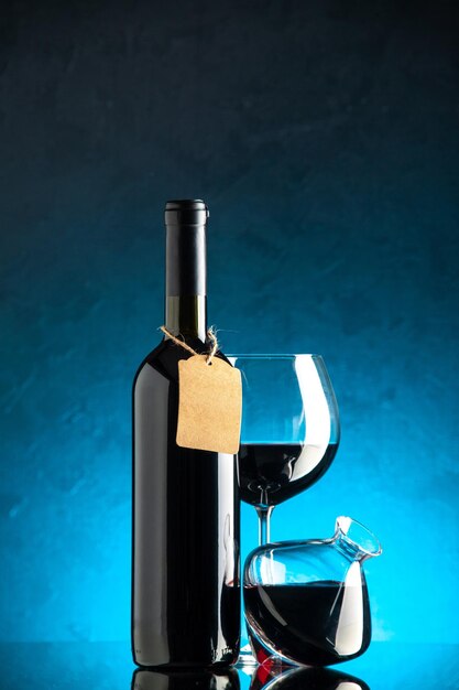 Vista frontal garrafa de vinho vinho tinto sobre fundo azul álcool cor uva preta bebida bar jantar foto