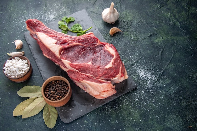 Vista frontal grande fatia de carne carne crua com pimenta no escuro animal refeição foto frango churrasco açougueiro