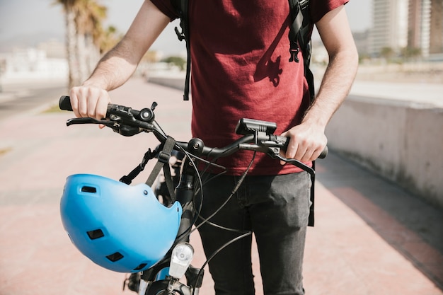 Foto grátis vista frontal homem andando ao lado de bicicleta