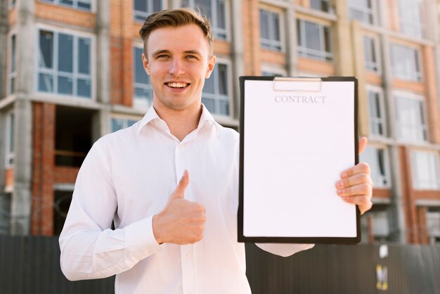 Vista frontal homem com contrato mostrando aprovação