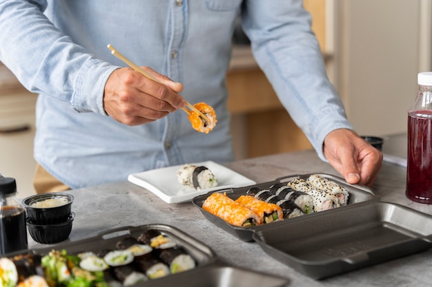 Vista frontal homem comendo sushi