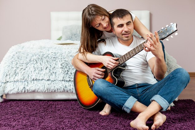 Foto grátis vista frontal homem e mulher tocando violão