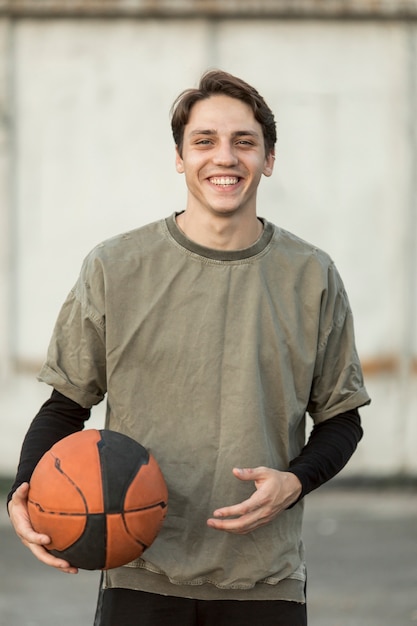 Vista frontal homem feliz com uma bola de basquete