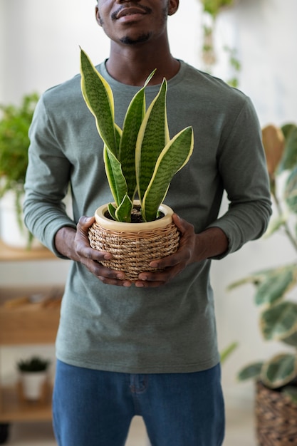 Vista frontal homem segurando o vaso de plantas