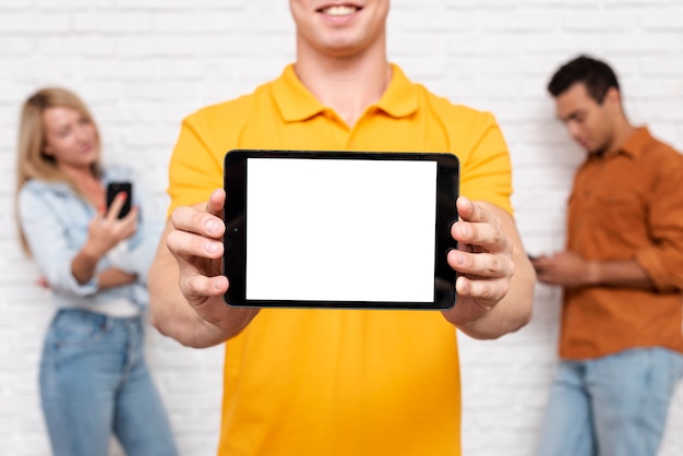 Foto grátis vista frontal homem segurando um tablet com maquete